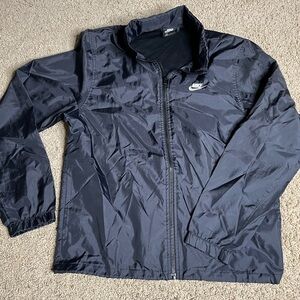 Black wind breaker/rain coat. hood comes out from the top zipper.